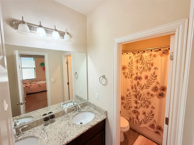 a bathroom with a granite countertop sink toilet and shower