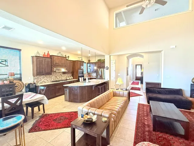 a large living room with stainless steel appliances kitchen island granite countertop furniture and a kitchen view