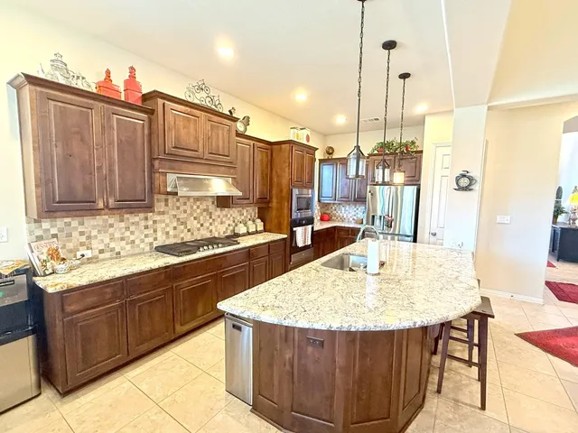 a kitchen with stainless steel appliances granite countertop a sink and cabinets