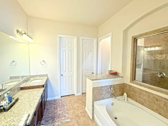 a bathroom with a tub sink and mirror