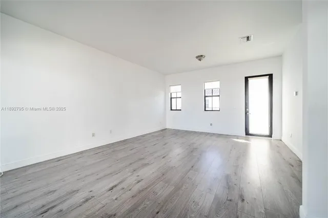 a view of a room with wooden floors and window