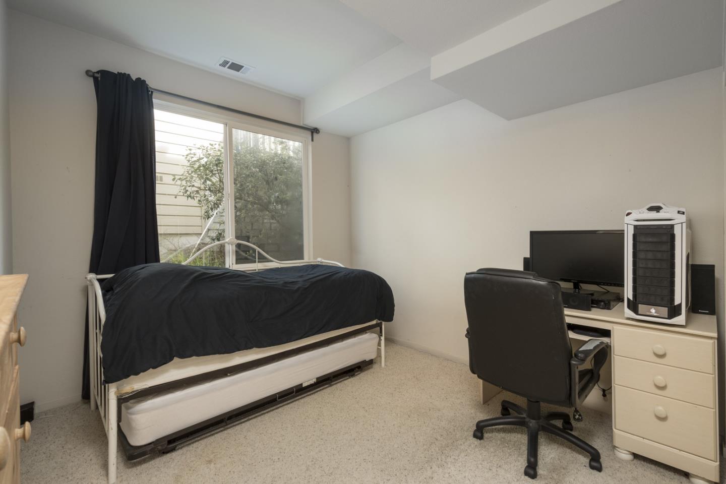 554 Monterey Road Pacifica, CA 94044 - Photo 23 of 32 a bedroom with a bed and a desk