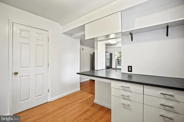 a kitchen with cabinets and wooden floor