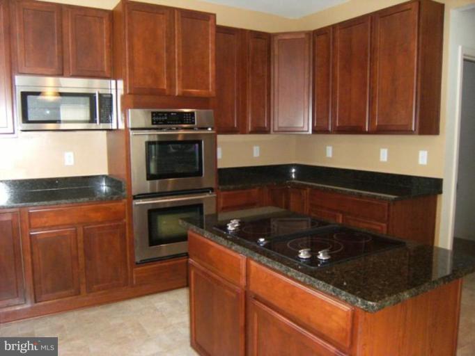 64 Mineral Springs Road Ranson, WV 25438 - Photo 4 of 12 a kitchen with granite countertop stainless steel appliances a stove a microwave and a sink