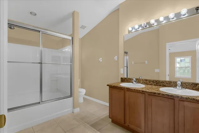 a bathroom with a granite countertop sink a mirror and a shower