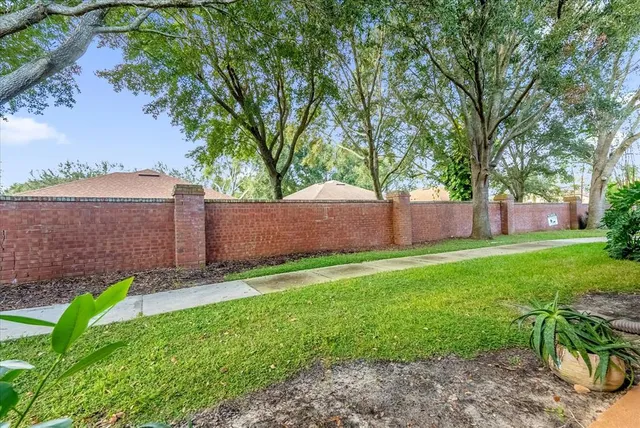 a view of a backyard with large tree and wooden fence