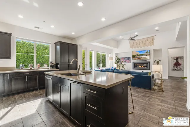 a kitchen with stainless steel appliances granite countertop a sink a stove a refrigerator and a refrigerator