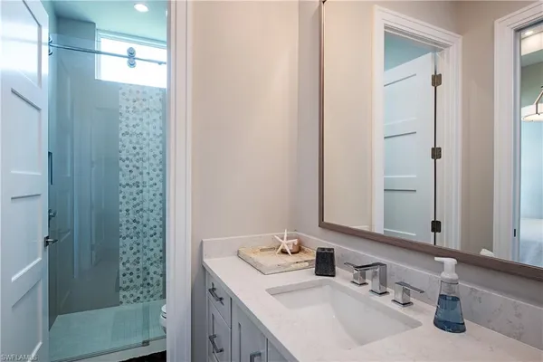 a bathroom with a sink a toilet and shower