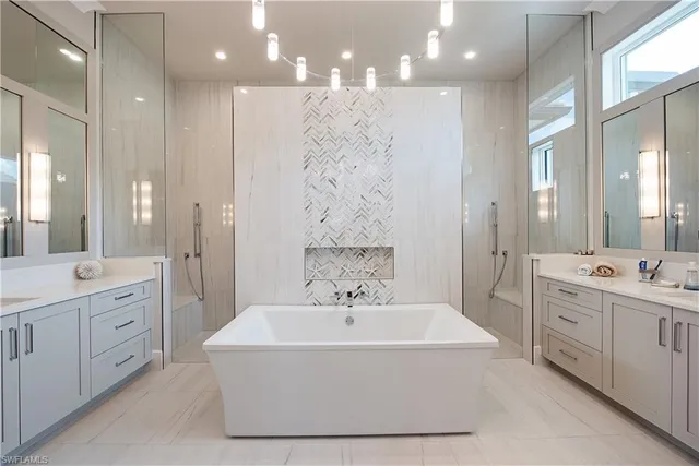 a spacious bathroom with a double vanity sink a mirror and a shower