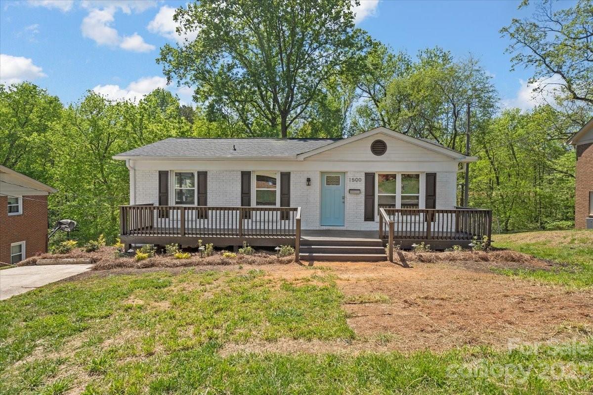 1500 Plumstead Road Charlotte, NC 28216 - Photo 1 of 30 a front view of a house with a yard covered with trees