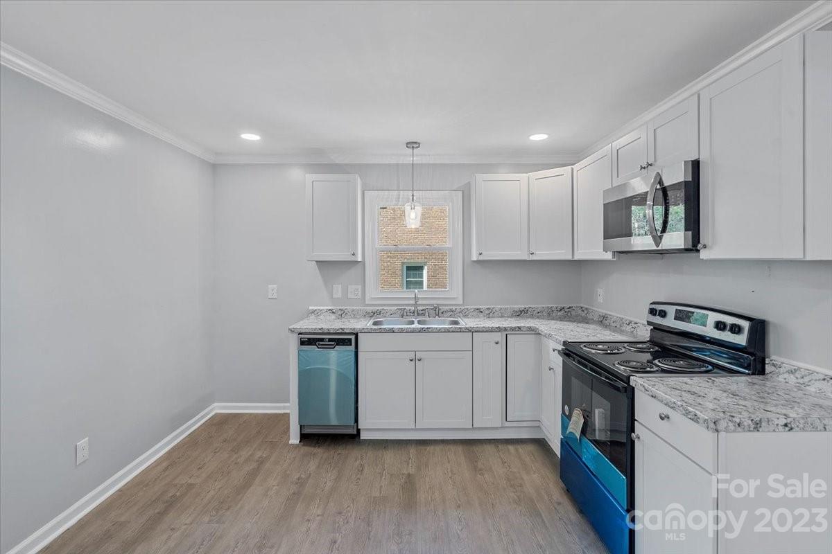 1500 Plumstead Road Charlotte, NC 28216 - Photo 11 of 30 a kitchen with stainless steel appliances granite countertop a sink and a stove top oven