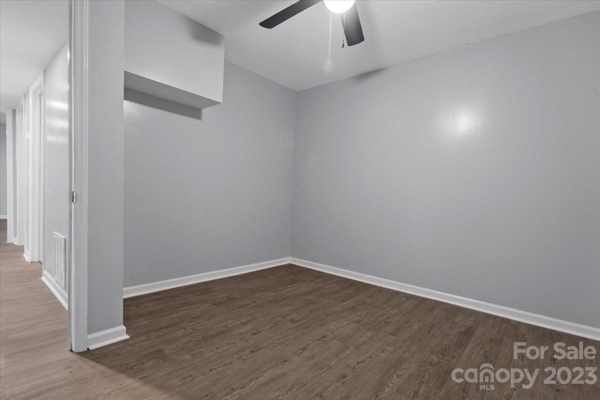 1500 Plumstead Road Charlotte, NC 28216 - Photo 23 of 30 an empty room with a ceiling fan and wooden floor