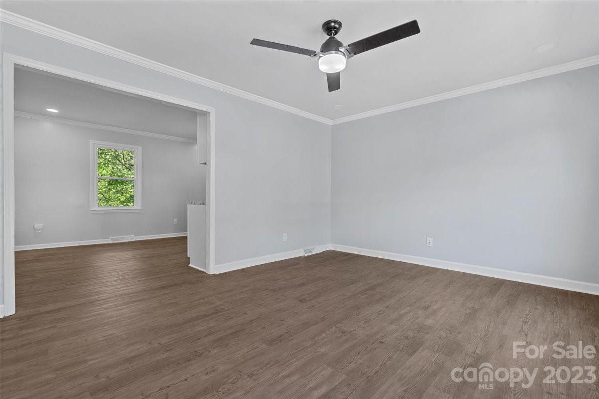 1500 Plumstead Road Charlotte, NC 28216 - Photo 4 of 30 an empty room with a window and wooden floor