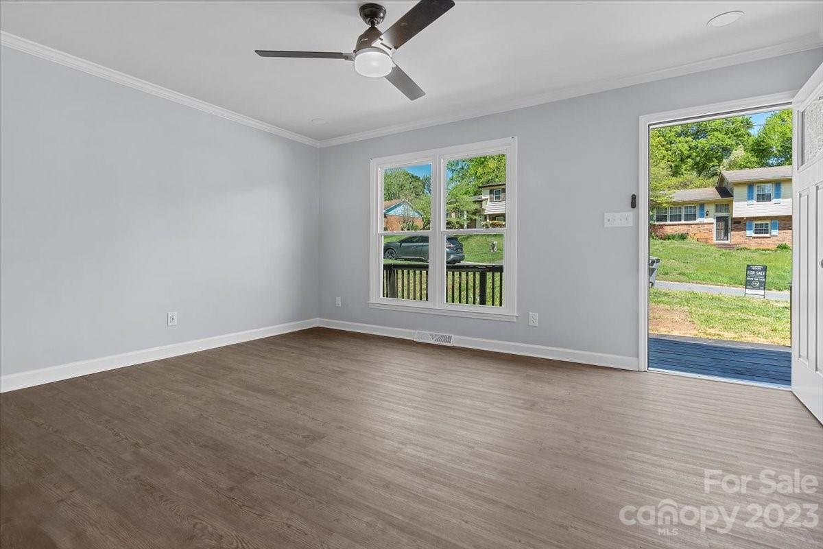 1500 Plumstead Road Charlotte, NC 28216 - Photo 6 of 30 an empty room with wooden floor fan and windows
