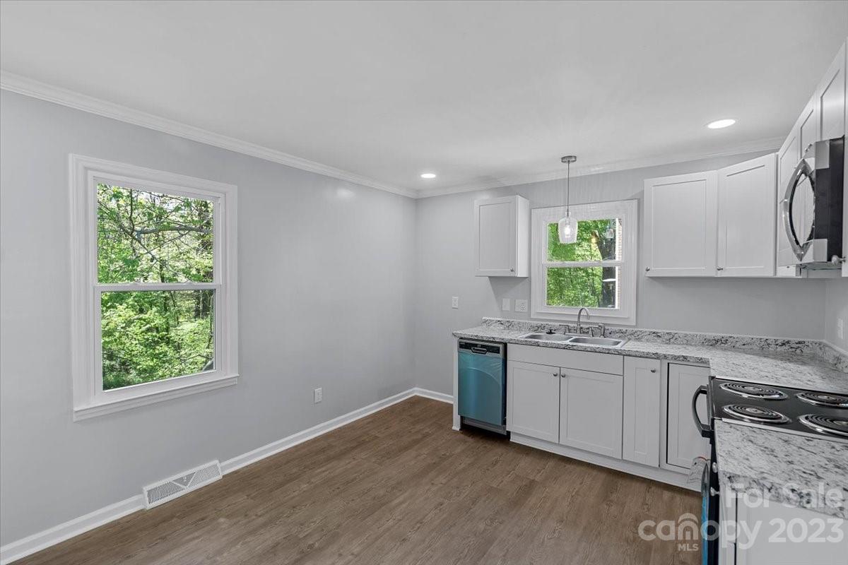 1500 Plumstead Road Charlotte, NC 28216 - Photo 9 of 30 a kitchen with granite countertop a stove a sink and a window
