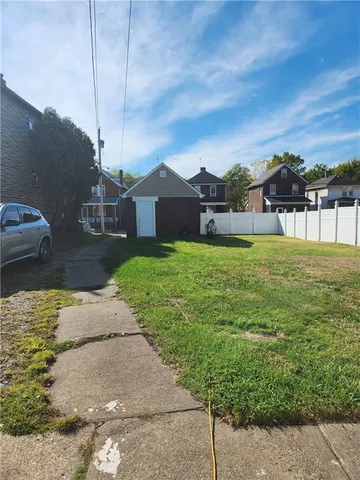 a view of a house with a yard and sitting area