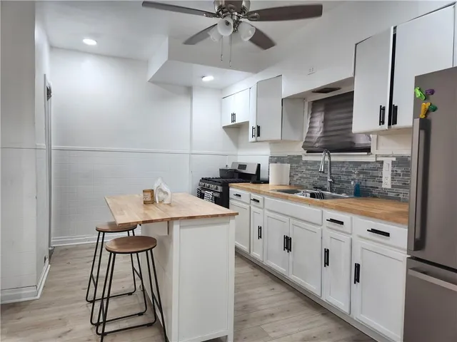 a kitchen with stainless steel appliances a stove a sink and a refrigerator