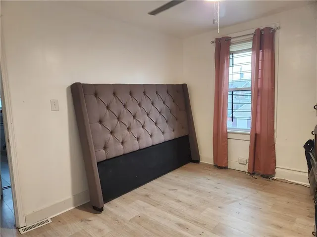 a view of a bedroom with wooden floor and a window