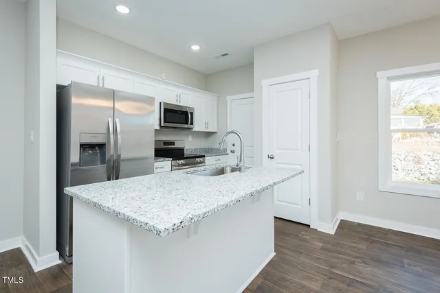 a kitchen with a stove microwave and sink