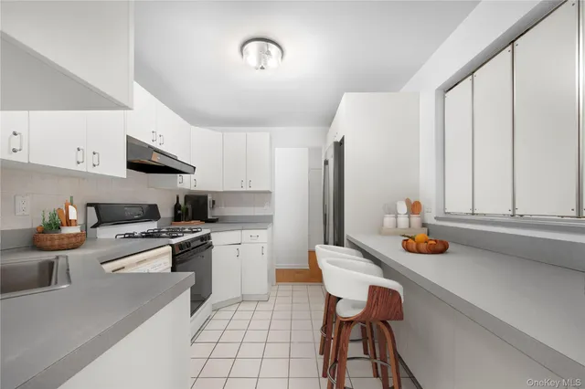 a kitchen with stainless steel appliances a sink stove and cabinets