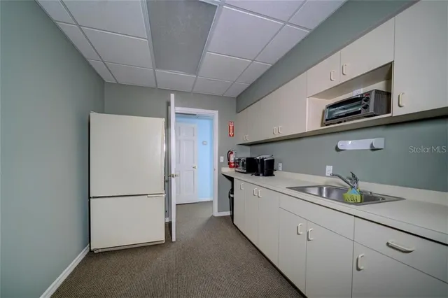 a view of a hallway with wooden floor and a living room