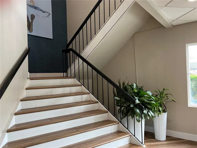 a view of a hallway with wooden floor and staircase