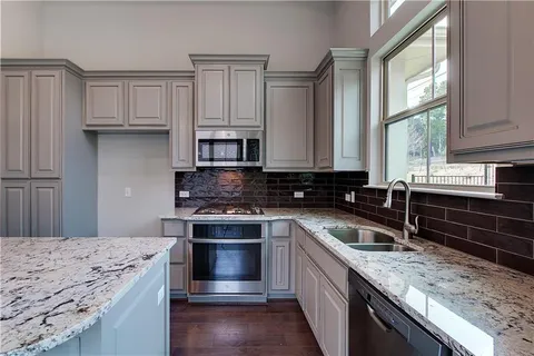 a kitchen with stainless steel appliances granite countertop a stove and a sink