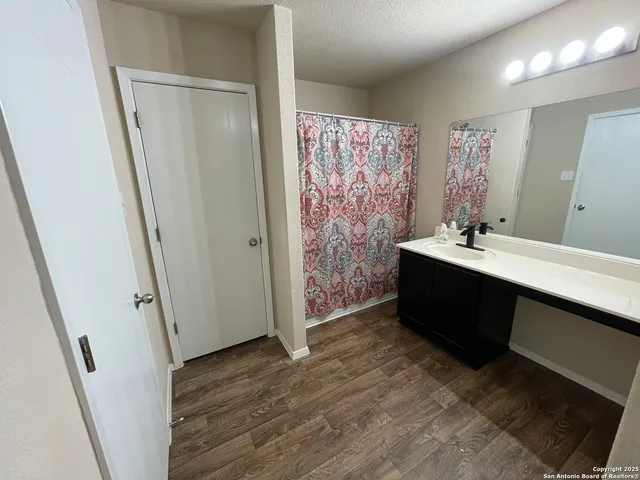 a bathroom with a sink a mirror a vanity and a shower