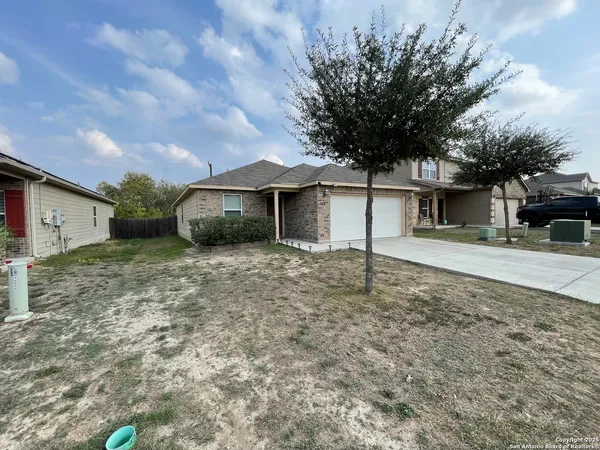 a front view of a house with a tree