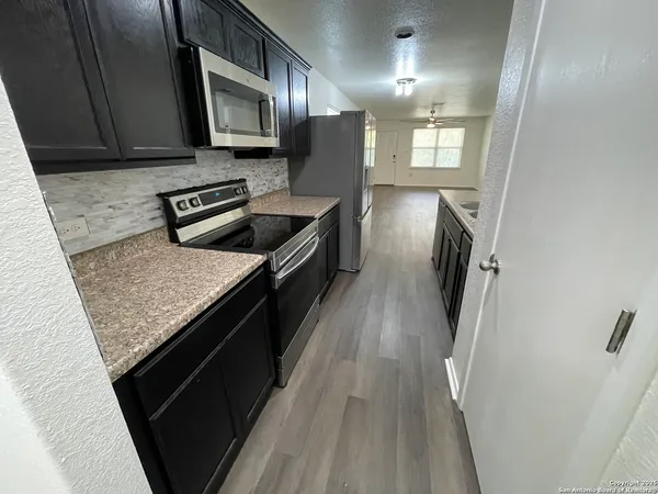 a kitchen with stainless steel appliances granite countertop a stove a sink and a refrigerator