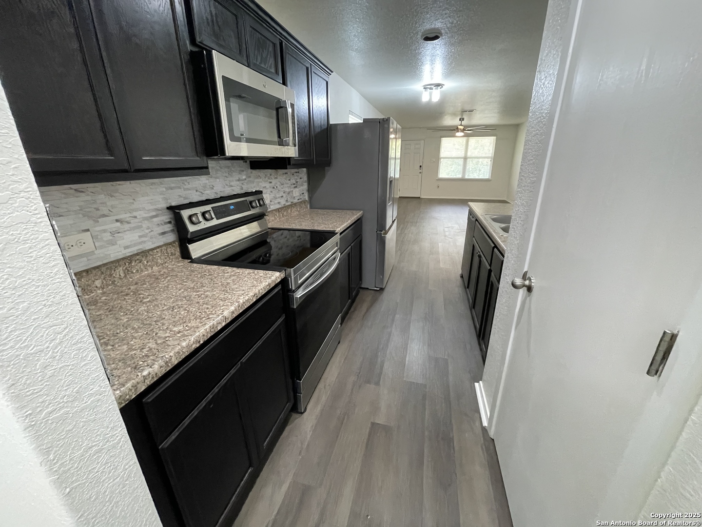10014 Raspberry Oak San Antonio, TX 78223 - Photo 6 of 20 a kitchen with stainless steel appliances granite countertop a stove a sink and a refrigerator