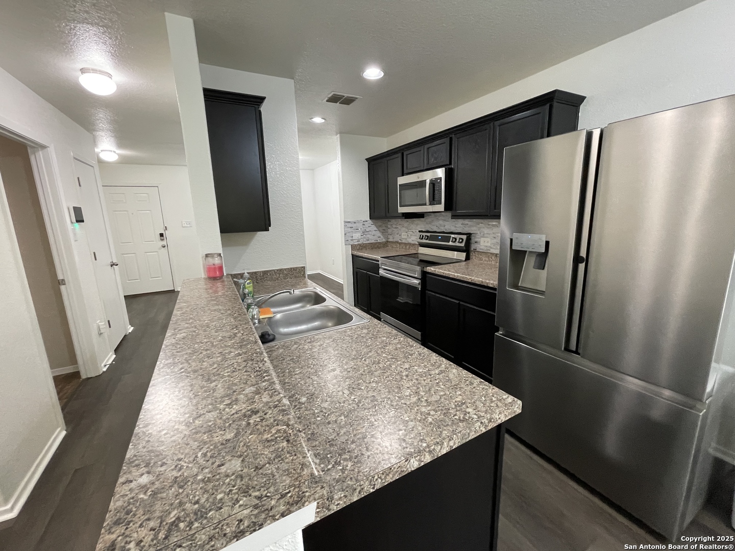 10014 Raspberry Oak San Antonio, TX 78223 - Photo 7 of 20 a kitchen with stainless steel appliances a refrigerator sink and microwave
