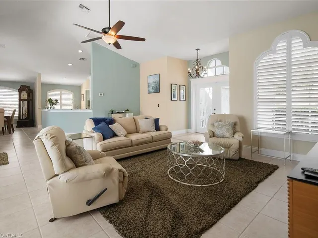 a living room with furniture a chandelier and a rug