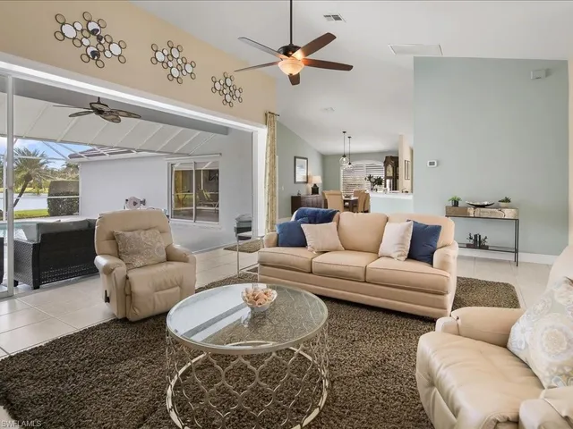 a living room with furniture a chandelier and a rug