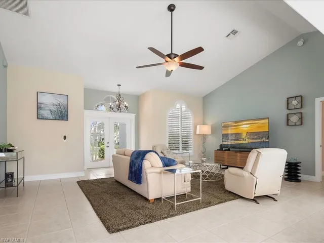 a living room with furniture ceiling fan and a window
