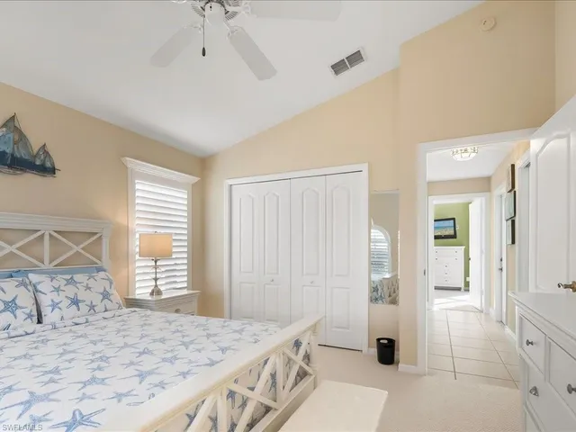 a spacious bedroom with a bed a rug and a large mirror