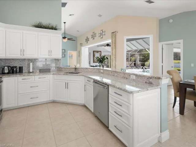 a kitchen with granite countertop white cabinets and white appliances