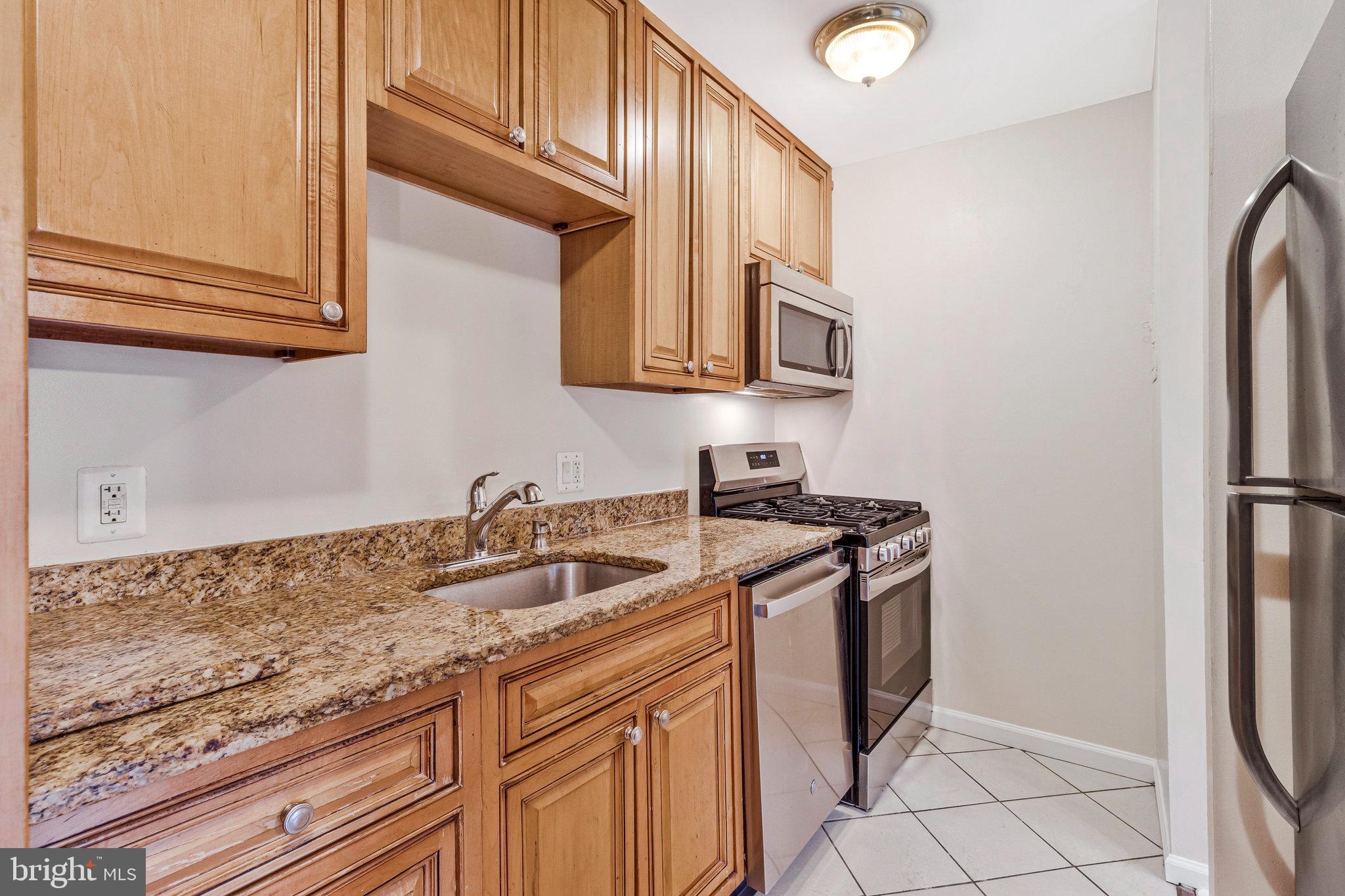 3802 Bel Pre Road, Unit 38025 Silver Spring, MD 20906 - Photo 16 of 36 a kitchen with granite countertop a sink stove and refrigerator