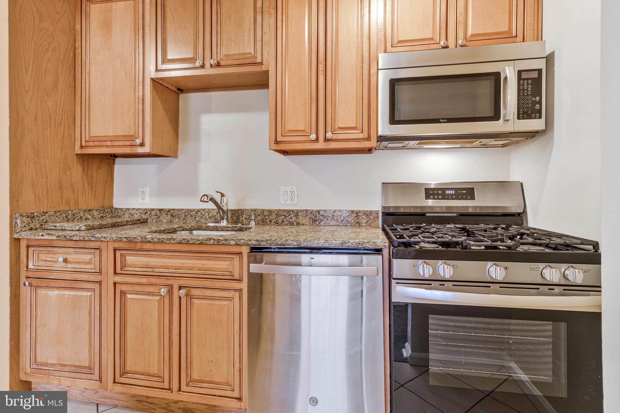 3802 Bel Pre Road, Unit 38025 Silver Spring, MD 20906 - Photo 17 of 36 a kitchen with granite countertop white cabinets and stainless steel appliances