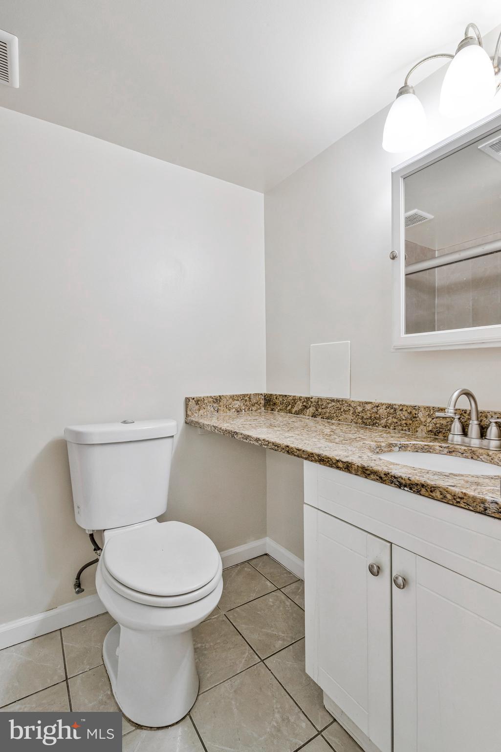 3802 Bel Pre Road, Unit 38025 Silver Spring, MD 20906 - Photo 24 of 36 a bathroom with a granite countertop toilet and a sink