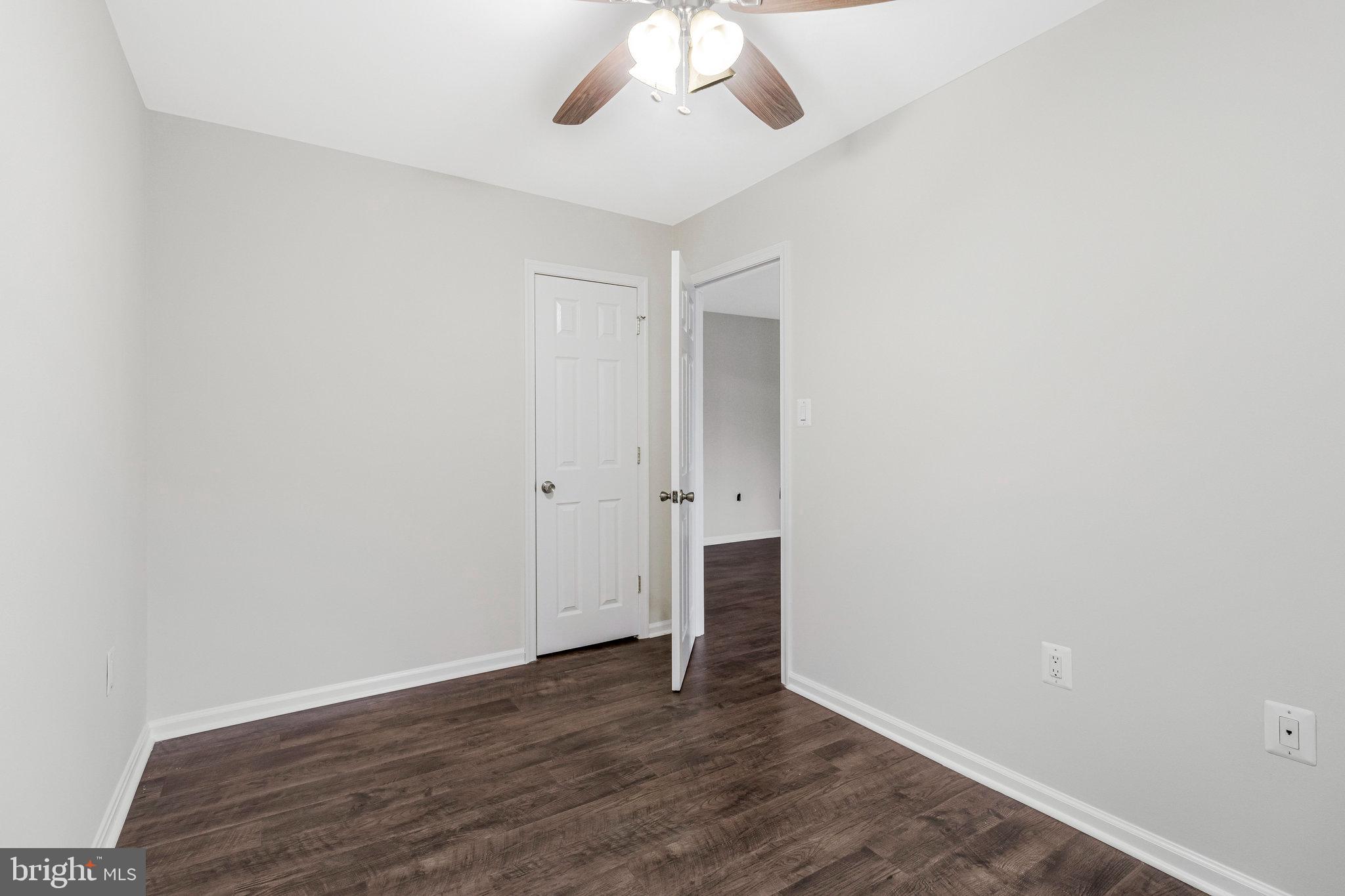 3802 Bel Pre Road, Unit 38025 Silver Spring, MD 20906 - Photo 6 of 36 an empty room with wooden floor and a ceiling fan