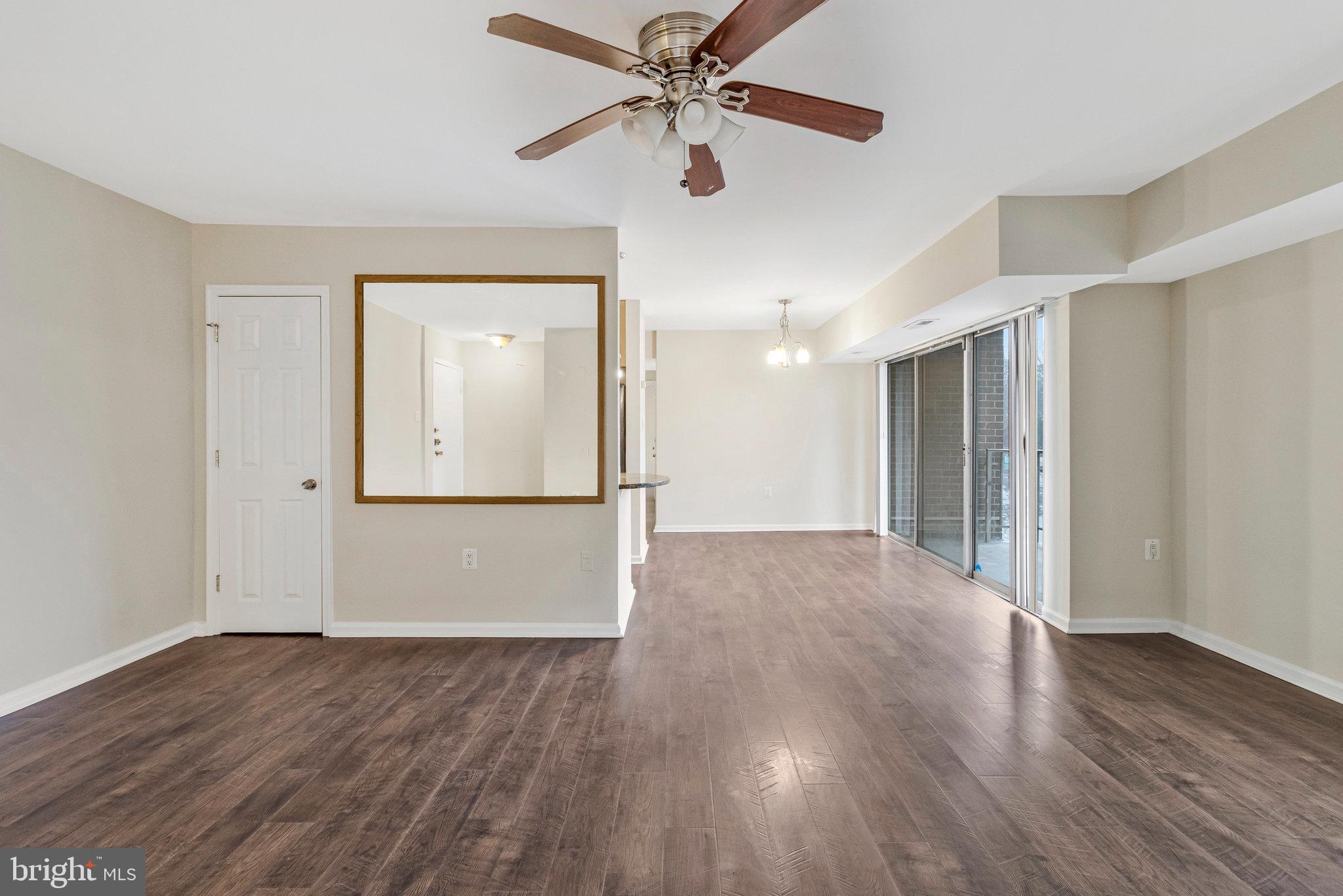 3802 Bel Pre Road, Unit 38025 Silver Spring, MD 20906 - Photo 7 of 36 a view of an empty room with wooden floor and a ceiling fan