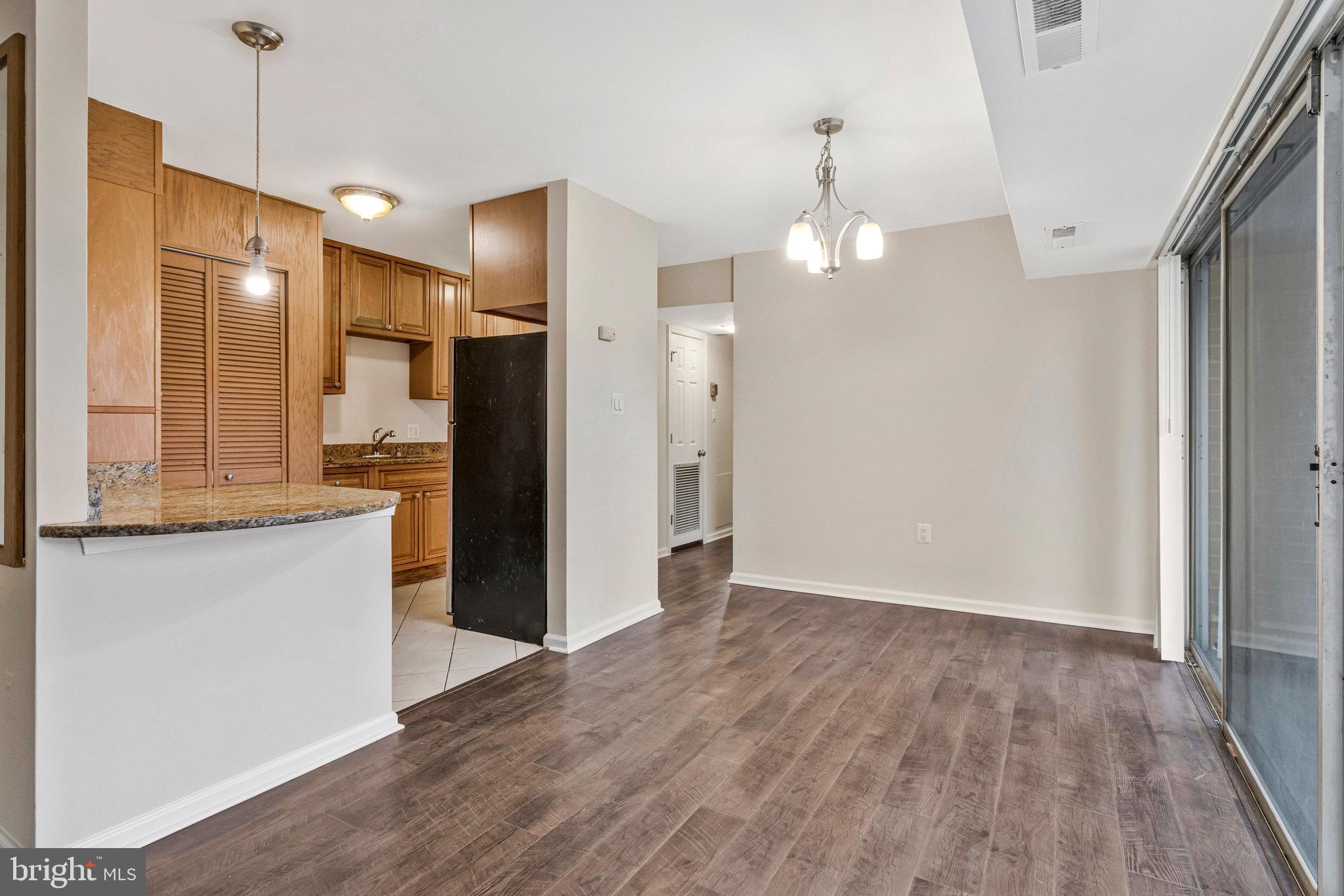 3802 Bel Pre Road, Unit 38025 Silver Spring, MD 20906 - Photo 9 of 36 a view of a kitchen with wooden floor and a refrigerator