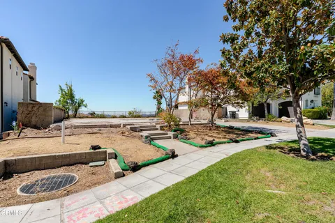a view of a backyard with couches under an umbrella