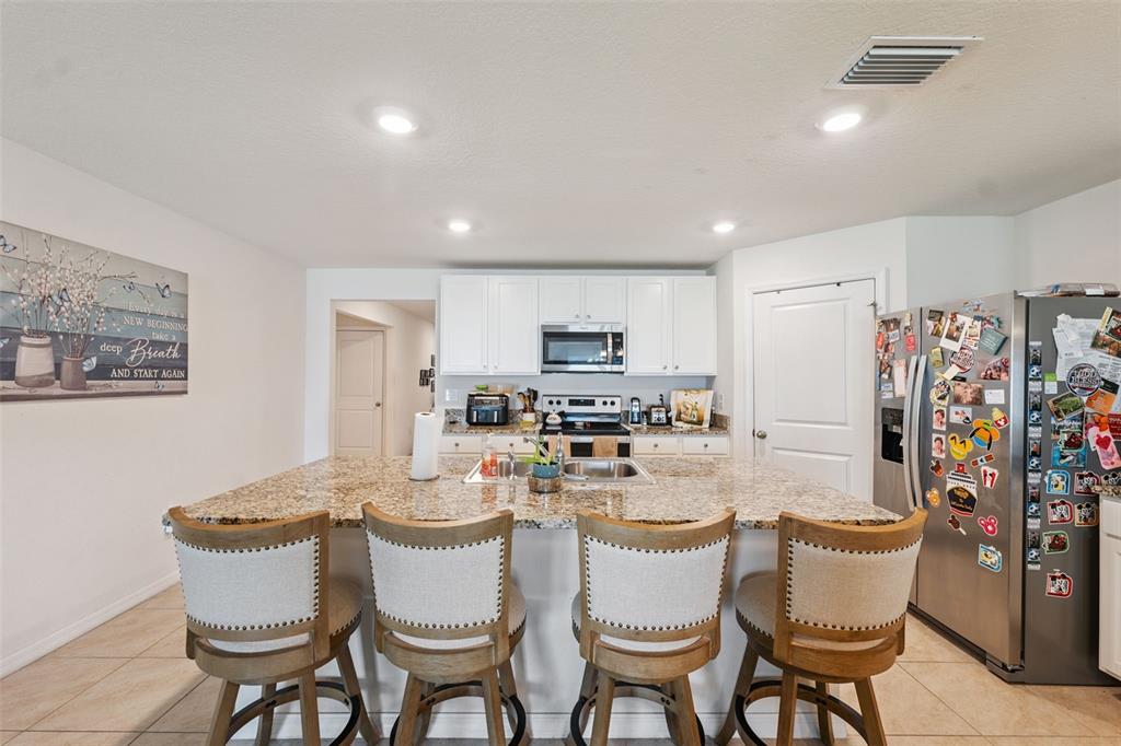 13196 Golden Lime Ave Spring Hill Spring Hill, FL 34609 - Photo 11 of 73 a dining room with furniture and a kitchen view