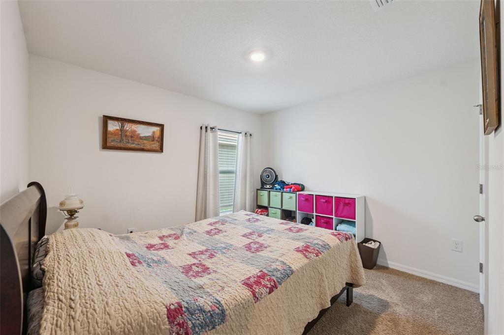 13196 Golden Lime Ave Spring Hill Spring Hill, FL 34609 - Photo 24 of 73 a bedroom with a bed and a chandelier