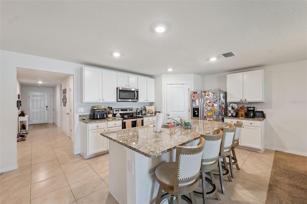 13196 Golden Lime Ave Spring Hill Spring Hill, FL 34609 - Photo 4 of 73 a kitchen with microwave a refrigerator and chairs