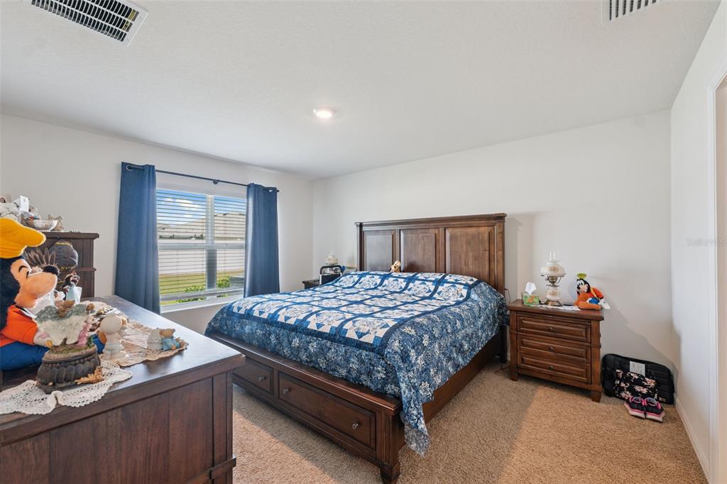 13196 Golden Lime Ave Spring Hill Spring Hill, FL 34609 - Photo 6 of 73 a bedroom with a bed and dresser