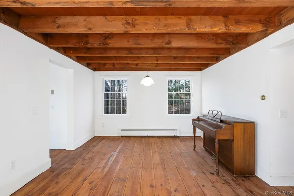 a view of room with wooden floor and windows