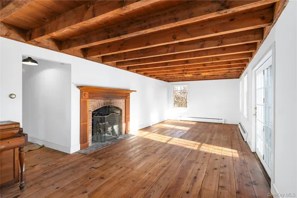 a view of empty room with wooden floor and fireplace